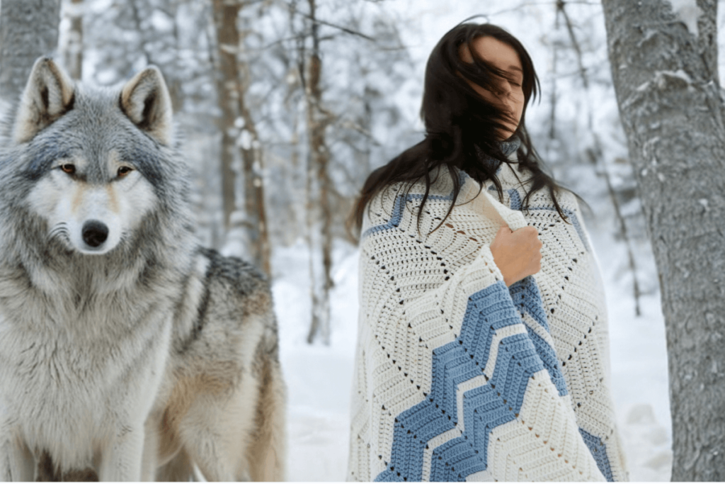 Auf dem Bild ist eine Winterlandschaft. Darin ist eine Frau, die in eine Decke eingehüllt ist. Neben ihr steht ein weißer Wolf. KI-generiertes Bild