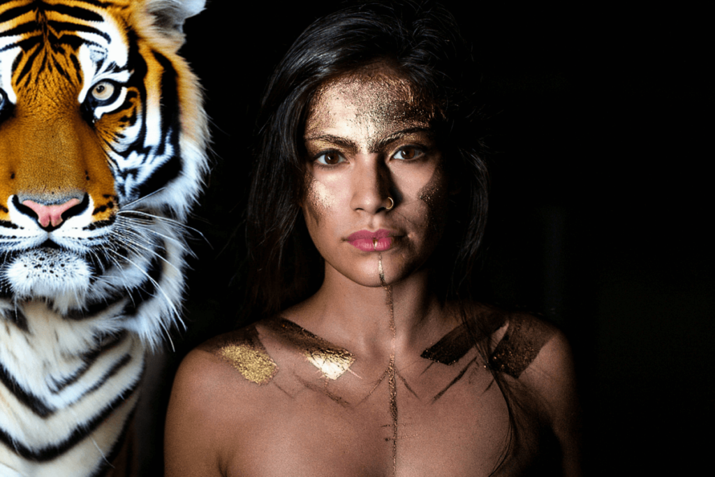 Der Hintergrund ist schwarz. Auf dem Bild ist eine Frau wie eine Göttin. Neben ihr steht eine Tigerin. KI-generiertes Bild.